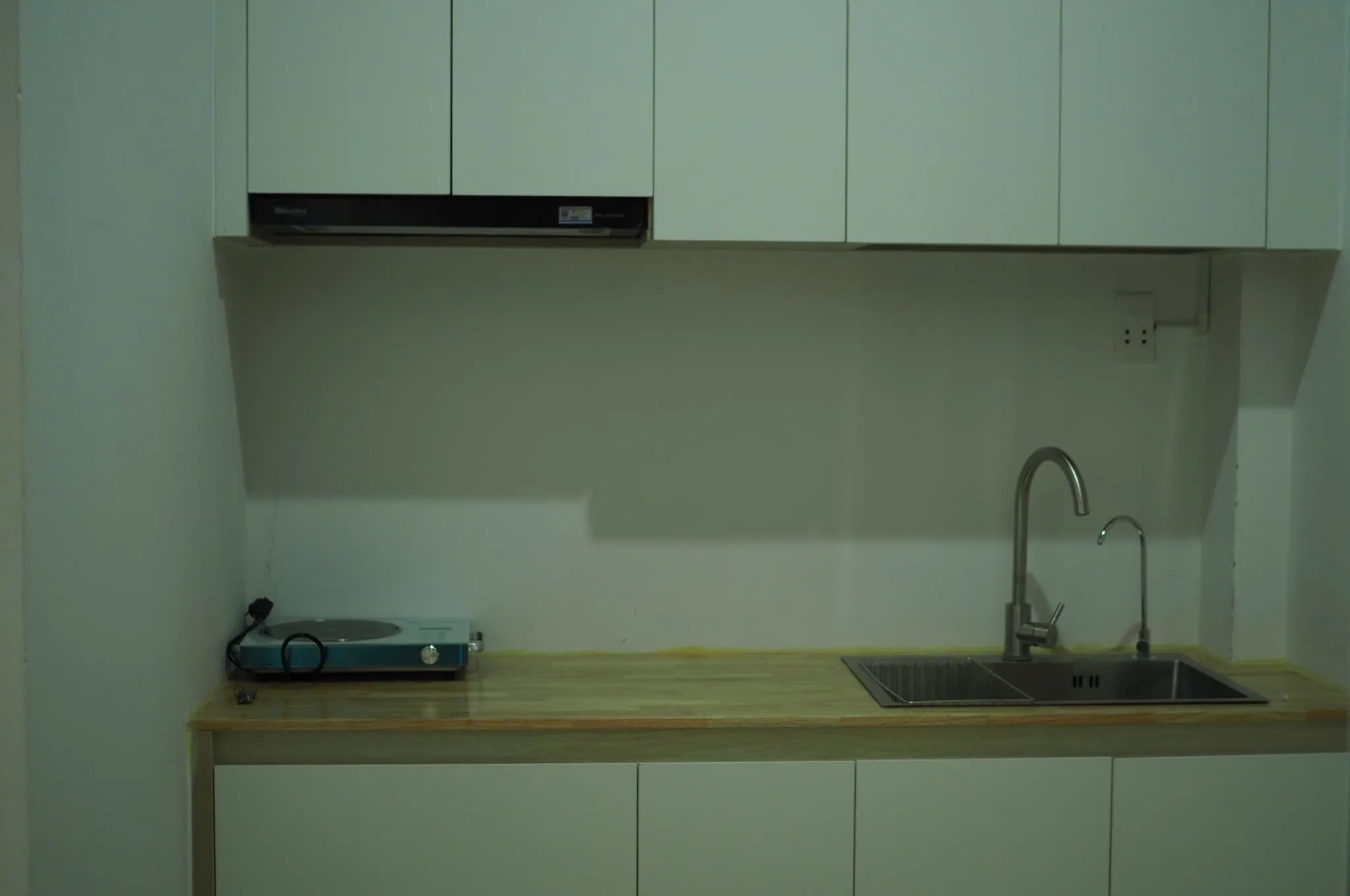 Studio kitchen with white cabinets, induction hob and sink