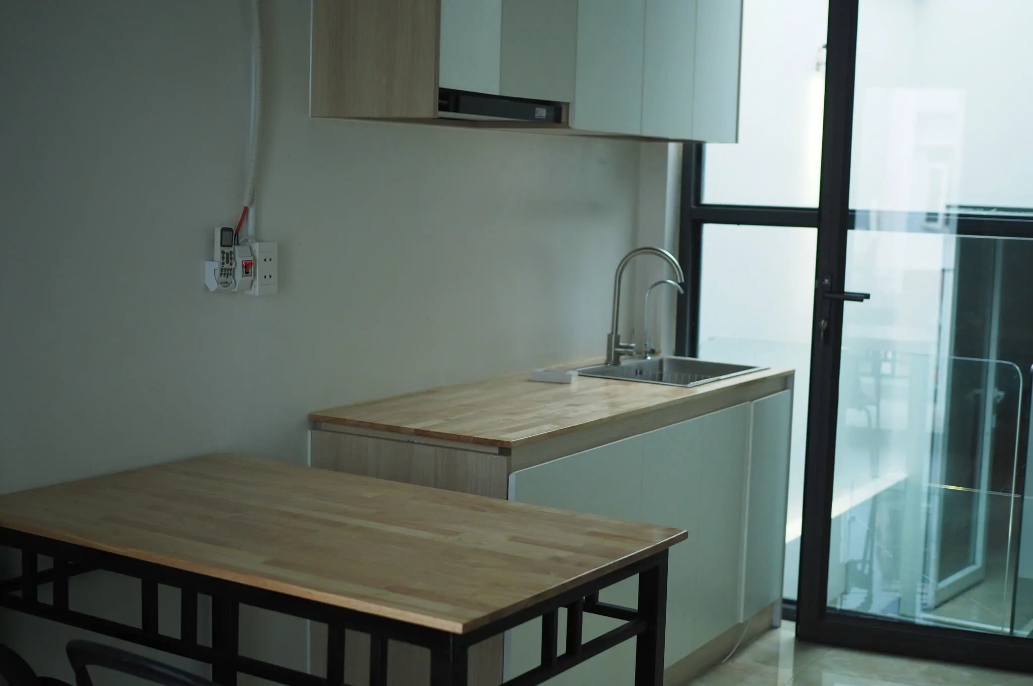 Galley kitchen, wood dining table and a large glass door