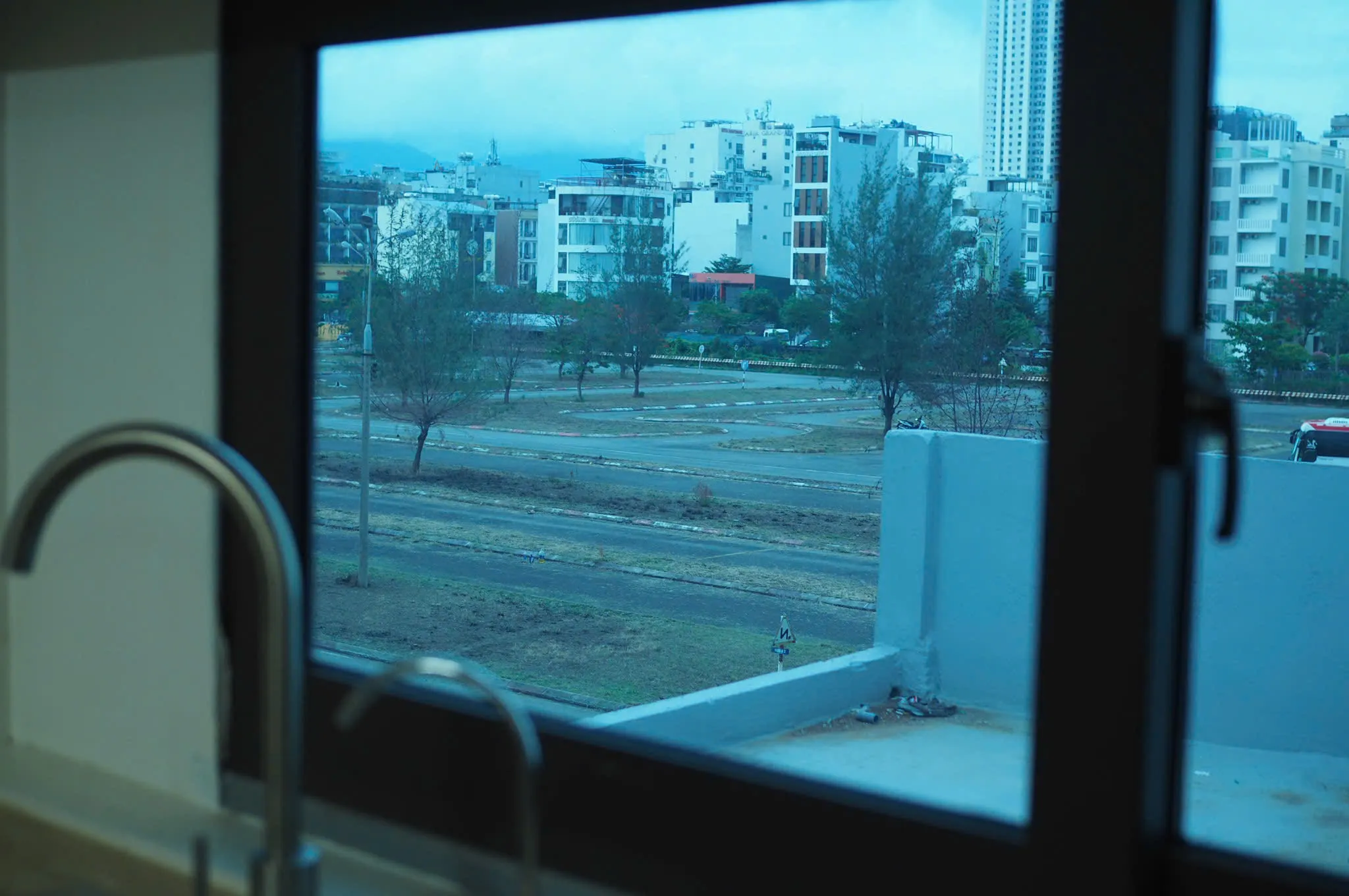 Kitchen window looking onto the street and mid-rise buildings